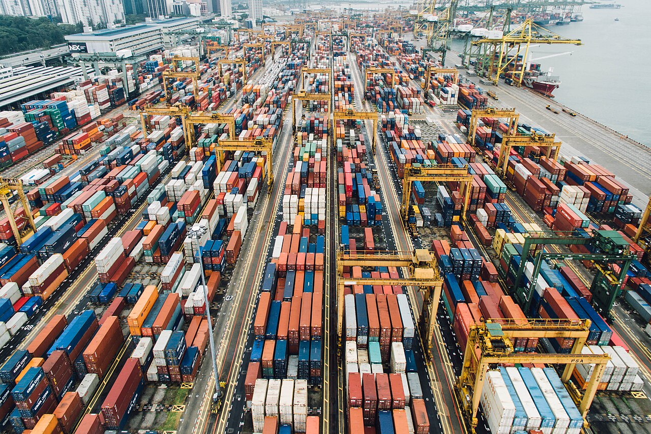 Shipping containers stacked at a large cargo port.